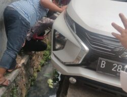 Menghindari Payung Pedagang Kaki Lima, Mobil Ini Malah Masuk Selokan